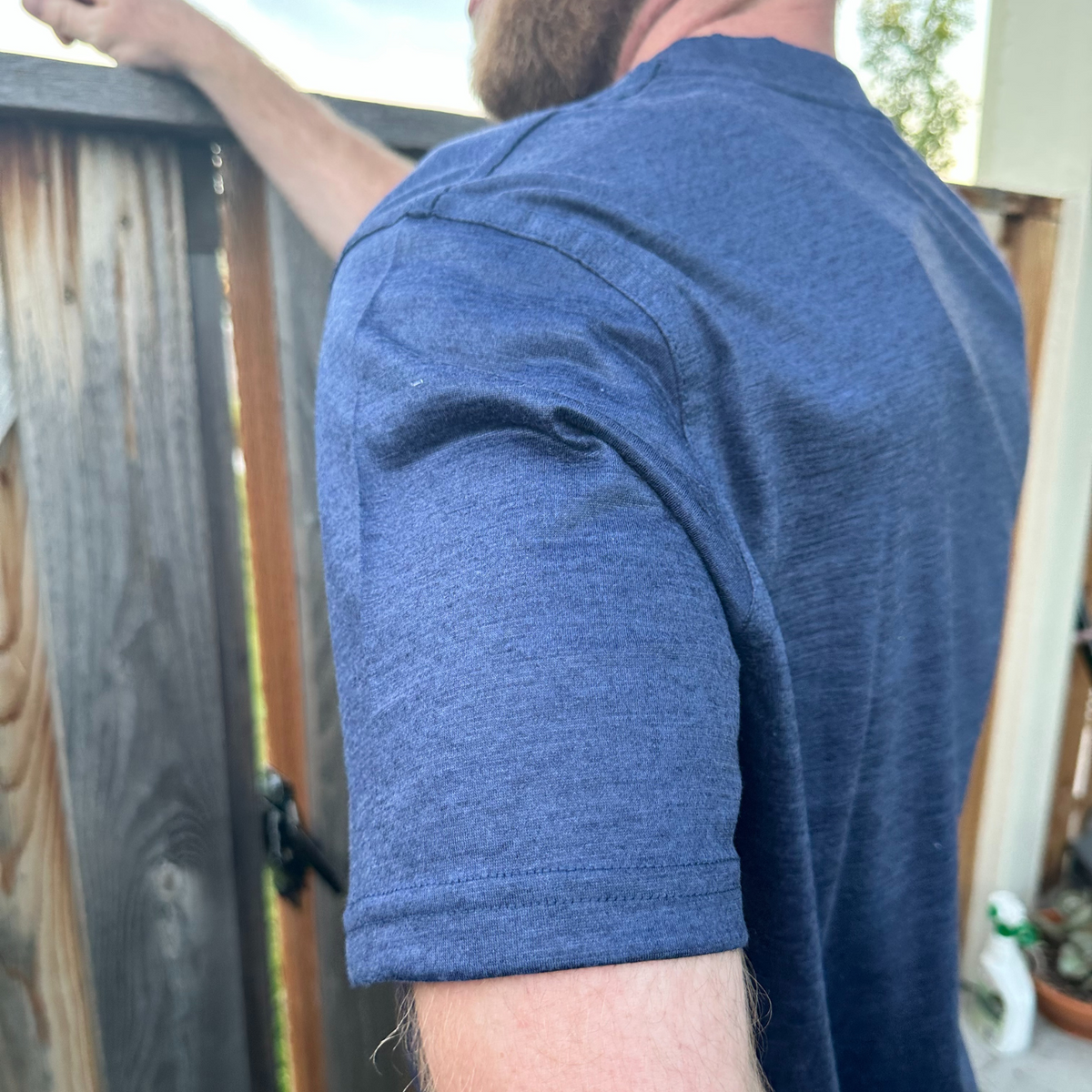 A close up of the sleeve of a navy blue Alpacas of Montana lightweight athletic activewear outerwear breathable moisture wicking antimicrobial soft comfortable exercise short sleeve alpaca men&#39;s performance tee for running sports exercise work out hiking climbing camping skiing biking