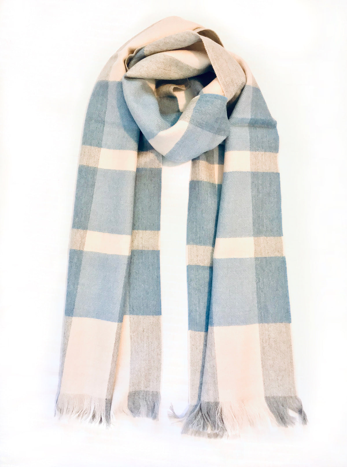 A product photo in front of a white background of a beautiful soft cozy luxury stylish fashion comfortable accessory sky blue, light gray, and natural white alpaca wool scarf with tassels.