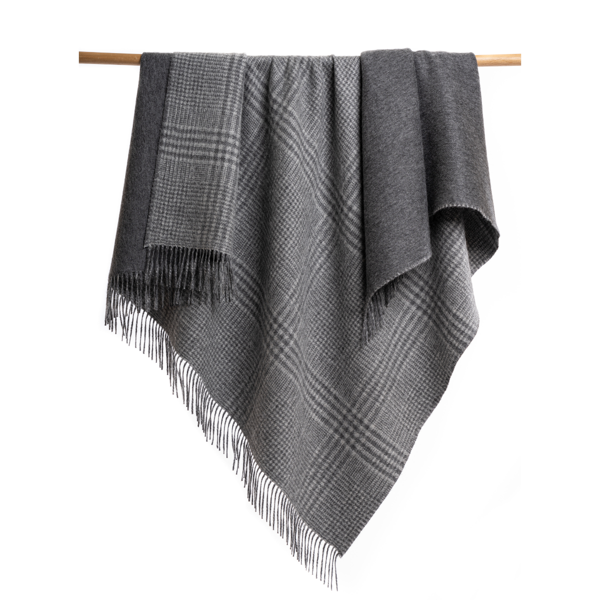 An Alpacas of Montana soft cozy luxury warm dark charcoal gray plaid blanket with a tasseled edge.