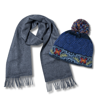 Gray scarf and blue knit hat with pom-pom on a white background