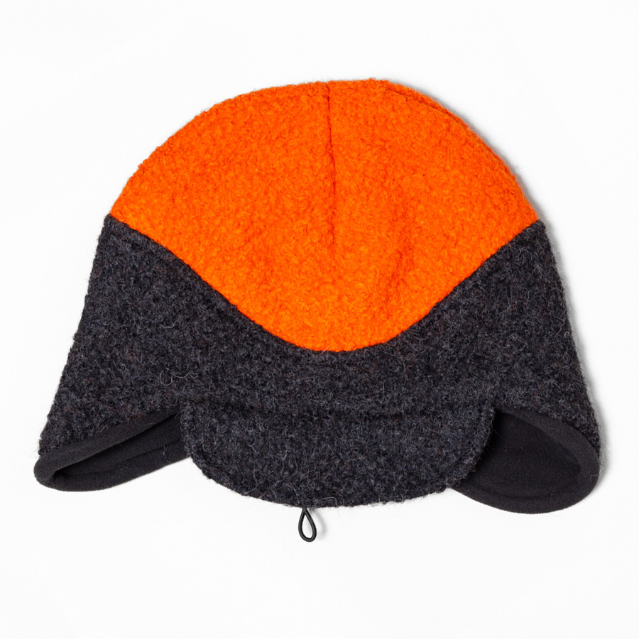 Front view of an orange and charcoal gray Extreme Warmth alpaca hat with ear flaps and a black fleece lining. The two-tone design highlights its rugged, high-visibility style and insulated alpaca construction for cold-weather comfort.