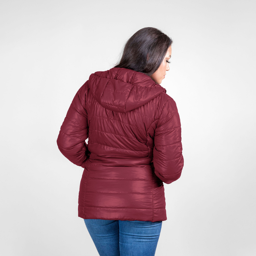 A woman with black hair facing away from the camera against a white background. She is wearing blue jeans and a cranberry cherry red Alpacas of Montana warm top layer insulated cozy comfortable thermal winter outerwear heavyweight alpaca wool lined electric peak parka jacket coat for skiing, snowboarding, ice fishing, hunting, camping, arctic, travel, outdoors