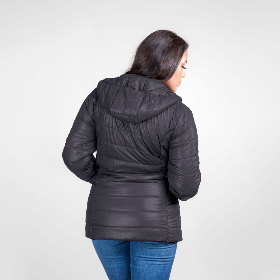 A woman with black hair facing away from the camera against a white background. She is wearing blue jeans and a black Alpacas of Montana warm top layer insulated cozy comfortable thermal winter outerwear heavyweight alpaca wool lined electric peak parka jacket coat for skiing, snowboarding, ice fishing, hunting, camping, arctic, travel, outdoors
