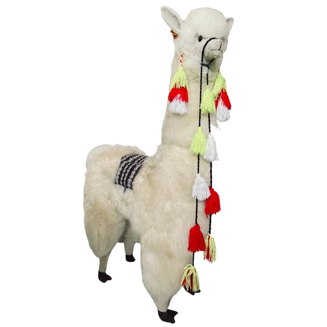 Product photo of a 45 inch tall soft fluffy natural white color alpaca wool plush figurine with red, lime, and white tassels hanging from its halter.