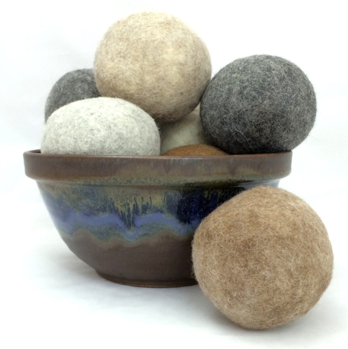 A colorful ceramic bowl full of alpaca wool dryer balls.