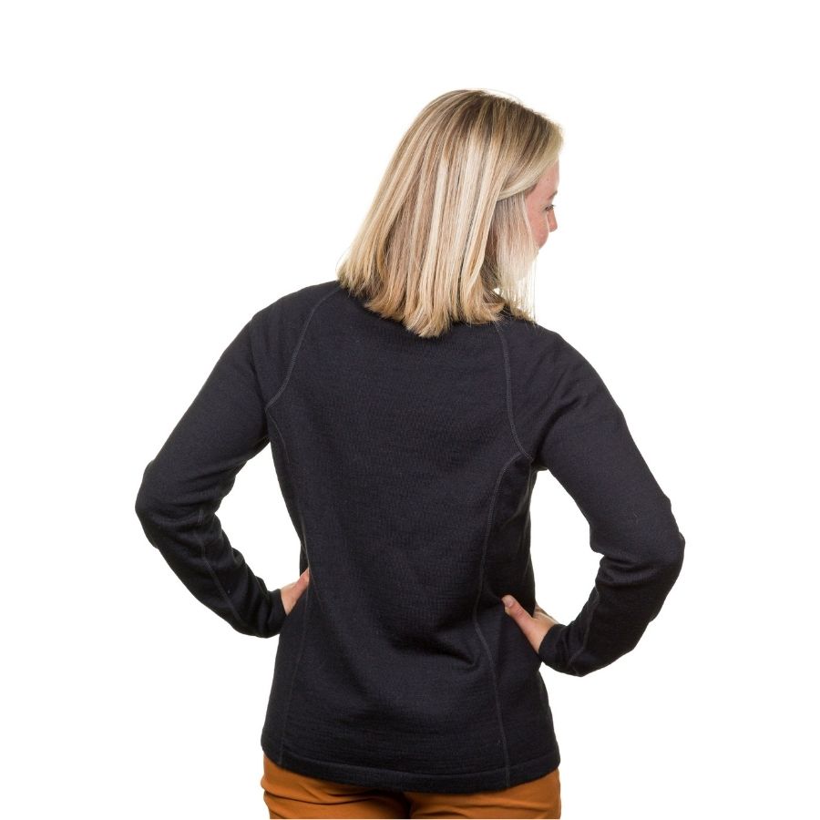 A blonde woman standing facing away from the camera against a white background of a black Alpacas of Montana warm thermal soft cozy comfortable activewear outerwear athletic moisture wicking antimicrobial women&#39;s fashion stylish luxury mid-layer quarter-zip alpaca wool long sleeve pullover top for outdoors camping climbing hiking skiing hunting fishing running winter.