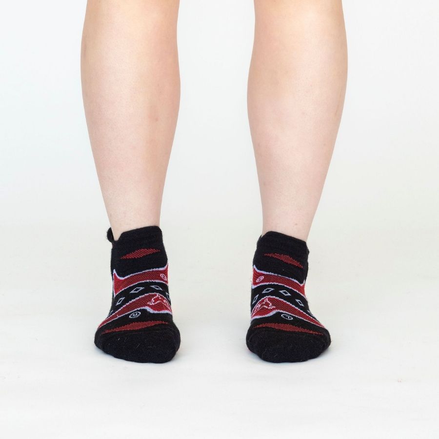A person&#39;s legs front-facing against a white background of the Alpacas of Montana soft comfortable breathable athletic outerwear activewear moisture wicking black, scarlet red, and white endurance sock for running, sports, hiking, exercise.