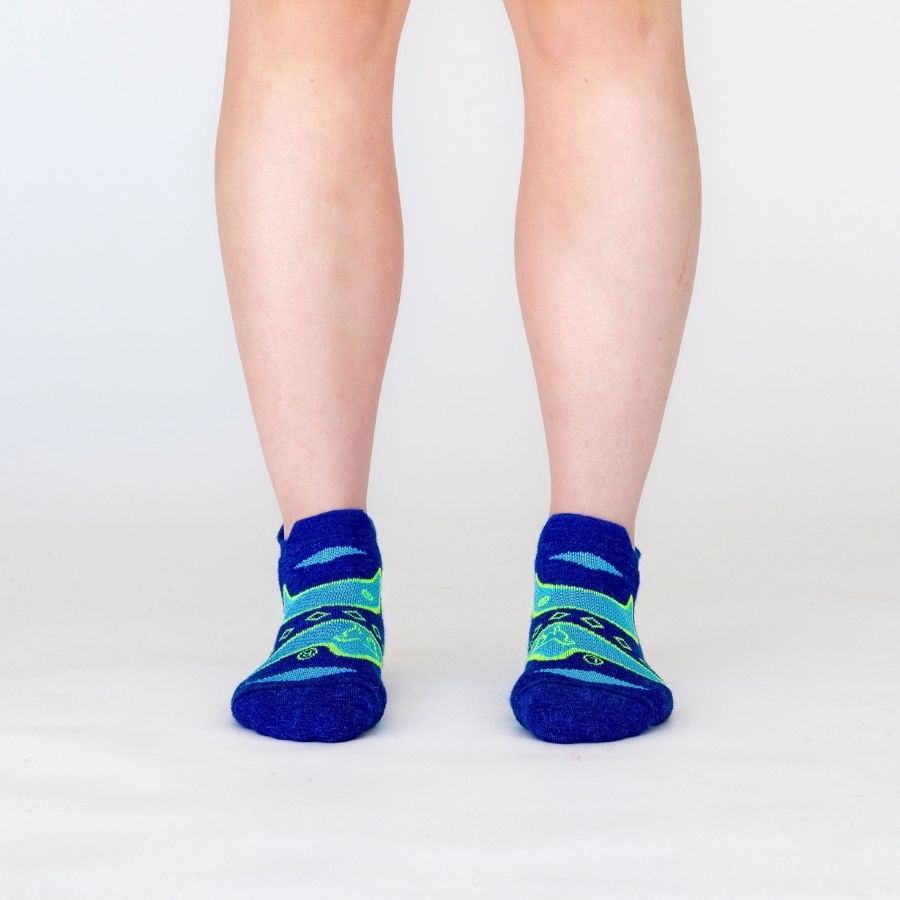 A front view of a person&#39;s lower legs against a white background of the Alpacas of Montana soft comfortable breathable athletic outerwear activewear moisture wicking blue, cyan, and lime yellow green endurance sock for running, sports, hiking, exercise.