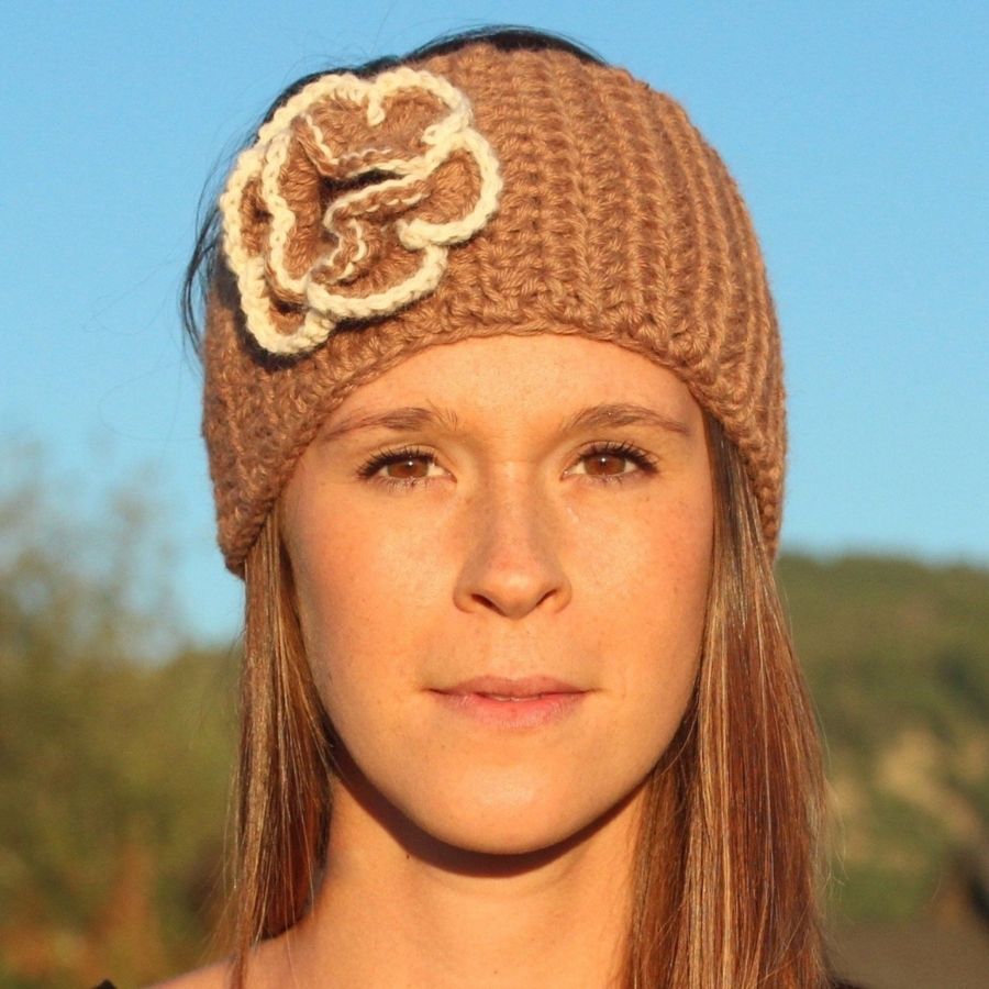woman smiling wearing brown alpaca wool headband with attached brown and white flower