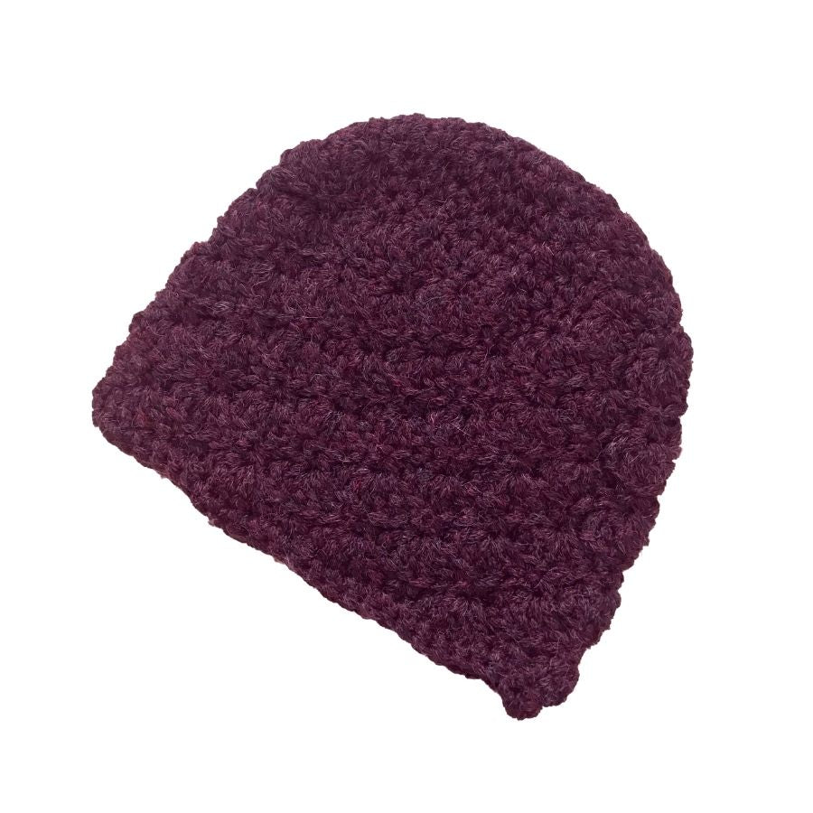 A product photo with a white background of a soft stylish cozy comfortable fashionable moisture wicking knitted crochet scallop pattern hat handmade in Montana from deep purple violet alpaca wool.