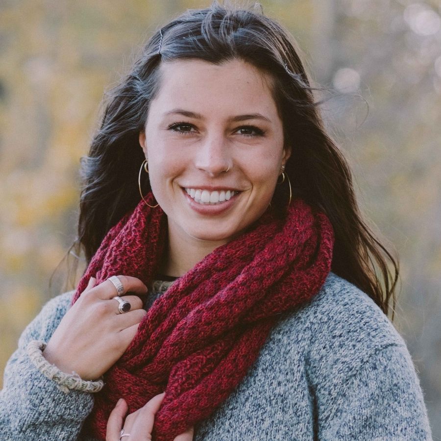 woman smiling and wearing deep red alpaca wool infinity scarf