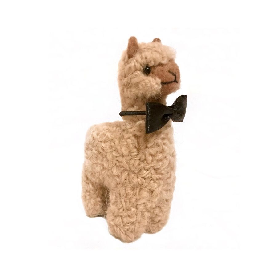 A fawn colored groom alpaca figurine and ornament wearing a black bow tie