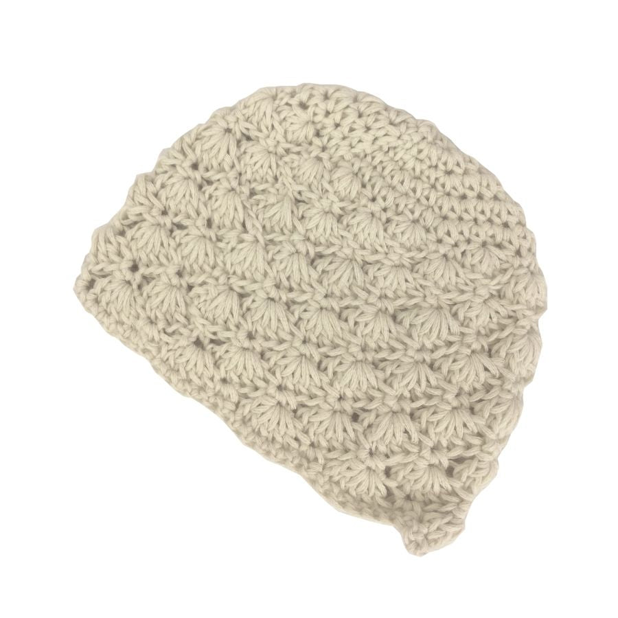 A product photo with a white background of a soft stylish cozy comfortable fashionable moisture wicking knitted crochet scallop pattern hat handmade in Montana from natural white alpaca wool.