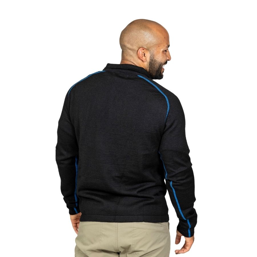 A smiling bald man with a black beard standing facing away from the camera in front of a white background. He is wearing khaki pants and a black with blue stitching Alpacas of Montana warm thermal soft cozy comfortable activewear outerwear athletic moisture wicking antimicrobial men&#39;s fashion stylish luxury mid-layer quarter-zip alpaca wool long sleeve pullover top for outdoors camping climbing hiking skiing hunting fishing running winter.
