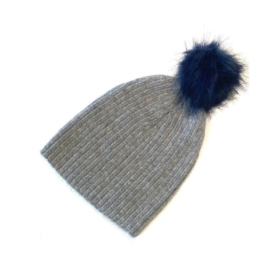 A product photo of a soft warm winter cozy moisture wicking comfortable fashionable light gray alpaca wool beartooth beanie with a navy blue pom pom.