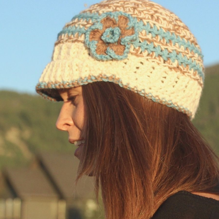 white brown and blue hand knit alpaca wool brimmed beanie hat with flower on woman