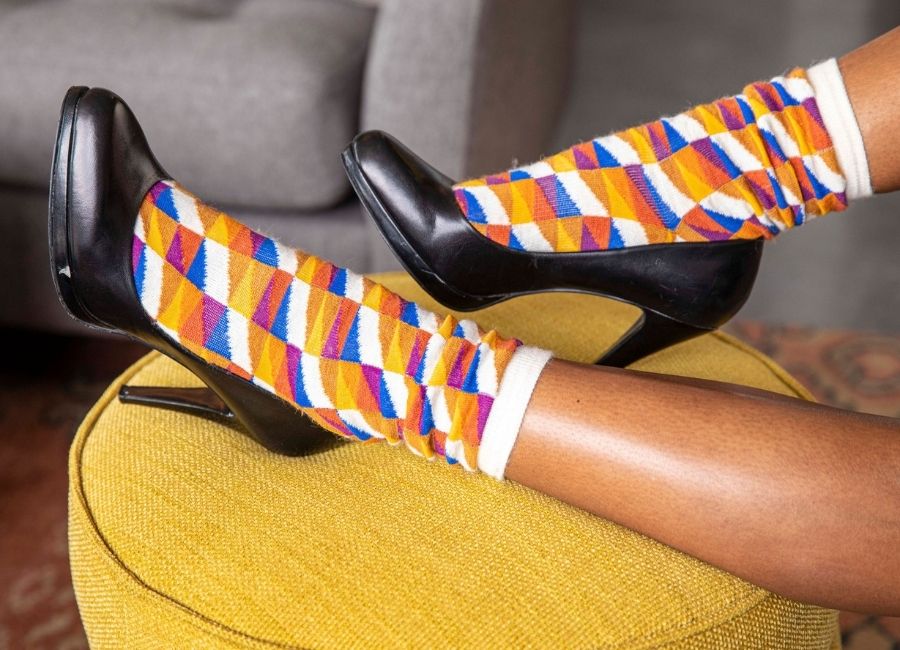 feet kicked up on yellow chair wearing alpaca wool swag socks in black heels
