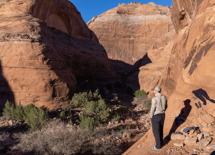 man standing in canyonlands wearing oatmeal and black alpaca wool base layer and blue mid crew alpaca socks