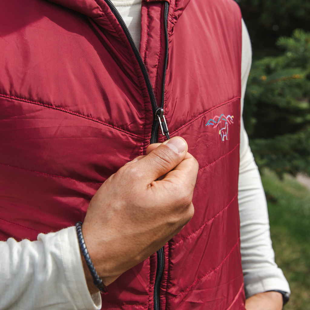 A close up photo of the zipper of a cranberry red Alpacas of Montana lightweight athletic activewear outerwear breathable moisture wicking antimicrobial soft comfortable exercise alpaca men's stretch lite vest for running sports exercise work out hiking climbing camping biking