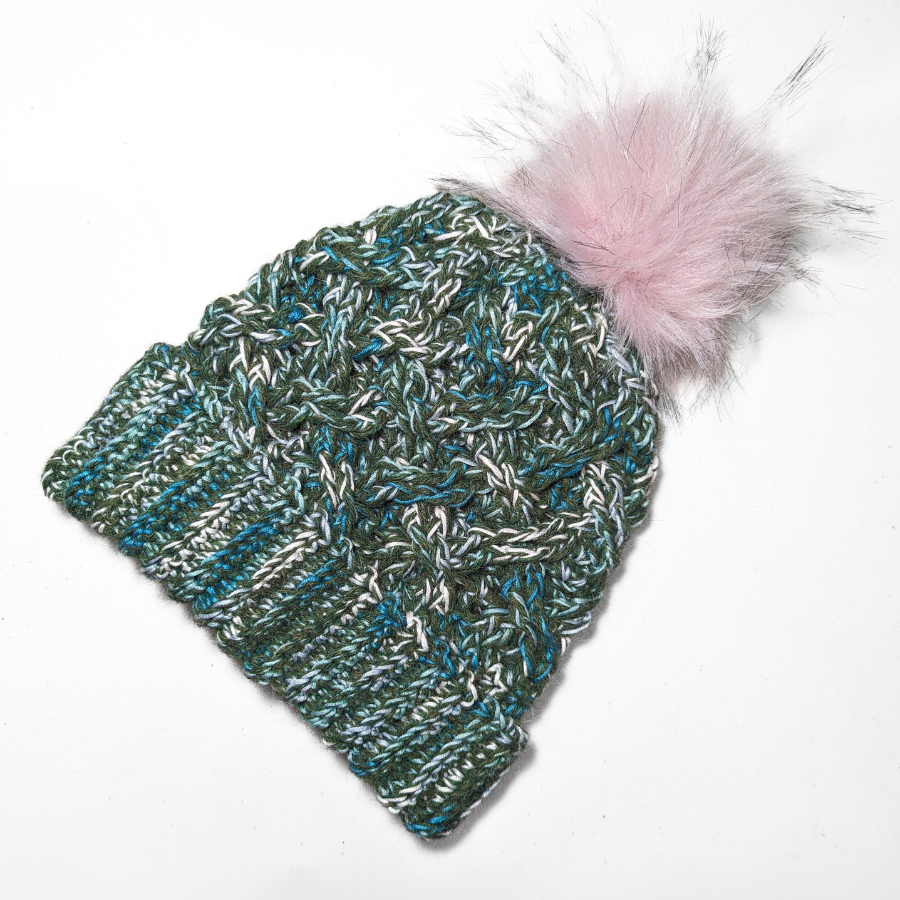 Moss green, teal, turquoise, seafoam, and white colored cozy soft warm handmade knitted crochet celtic hat with a light pink pom pom made in Montana by Alpacas of Montana.