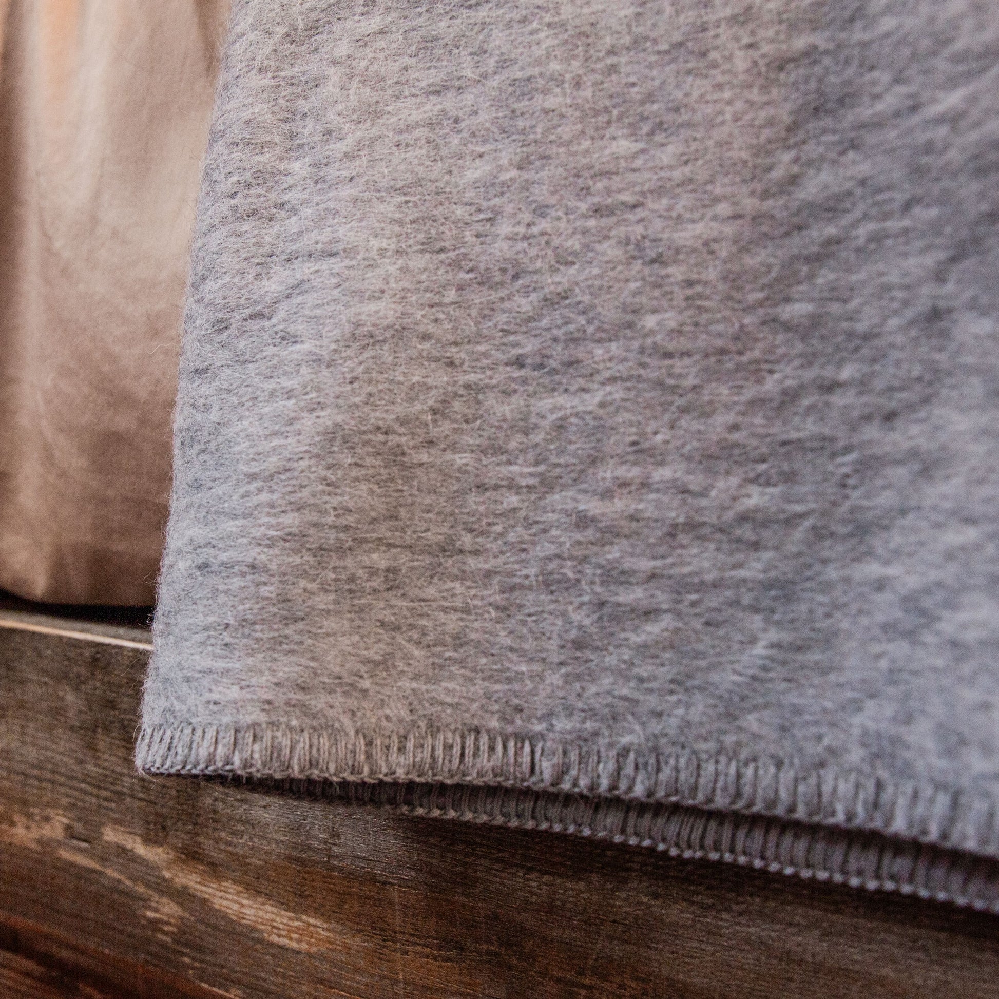 A close up shot of a medium gray Alpacas of Montana soft warm thermal moisture wicking lightweight plush king or queen size alpaca wool blanket.