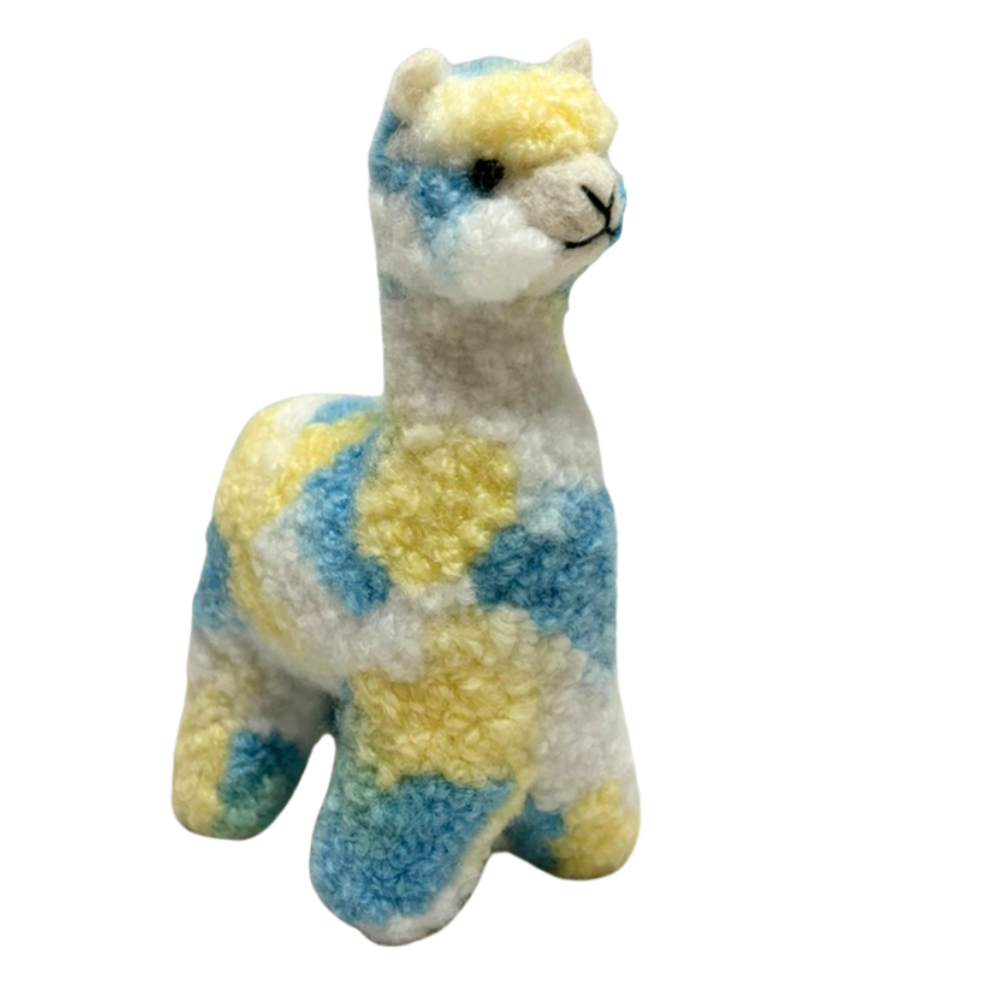 Felted toy alpaca with blue and yellow pattern on a white background
