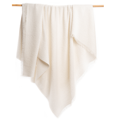 Beige towel hanging on a wooden rod against a white background