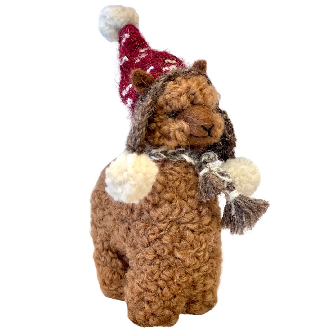 Brown alpaca wearing a christmas red Chullo hat with pompoms