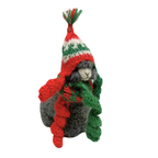 Knitted sheep ornament with a red and green hat and scarf on a white background