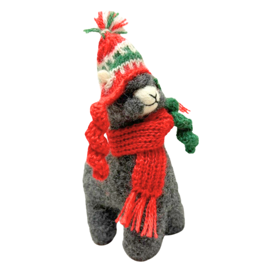 Stuffed animal toy wearing a red scarf and festive hat on a white background