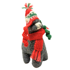Stuffed animal toy wearing a red scarf and festive hat on a white background