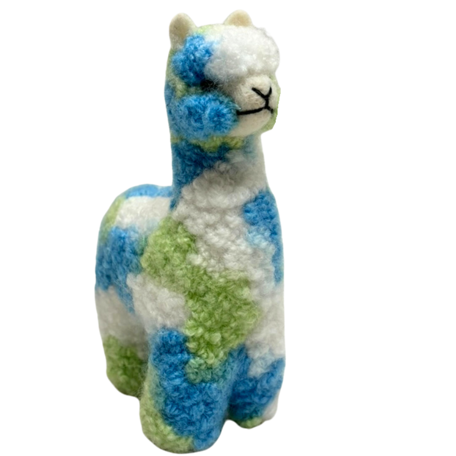 Plush toy llama with blue and green pattern on a white background