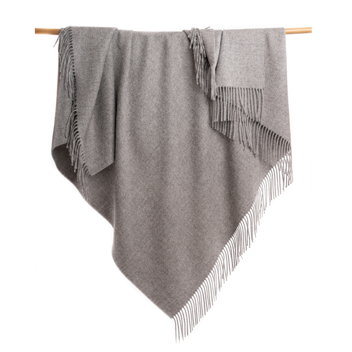 An Alpacas of Montana soft cozy luxury warm medium light charcoal gray blanket with a tasseled edge.