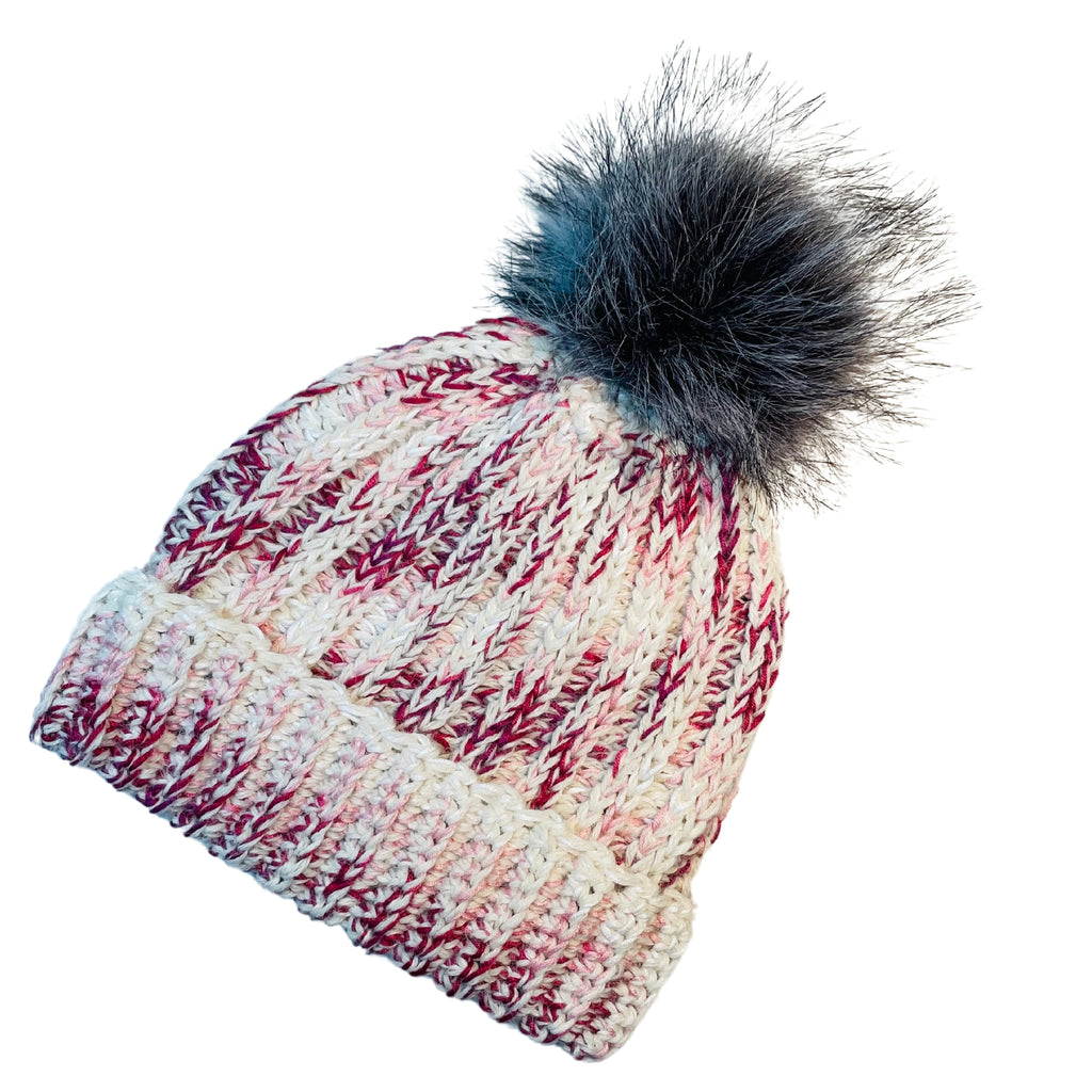 Fuchsia, dark pink, light pink, carnation, and white colored cozy soft warm handmade knitted crochet ridge ribbed hat with a multi-gray pom pom made in Montana by Alpacas of Montana.