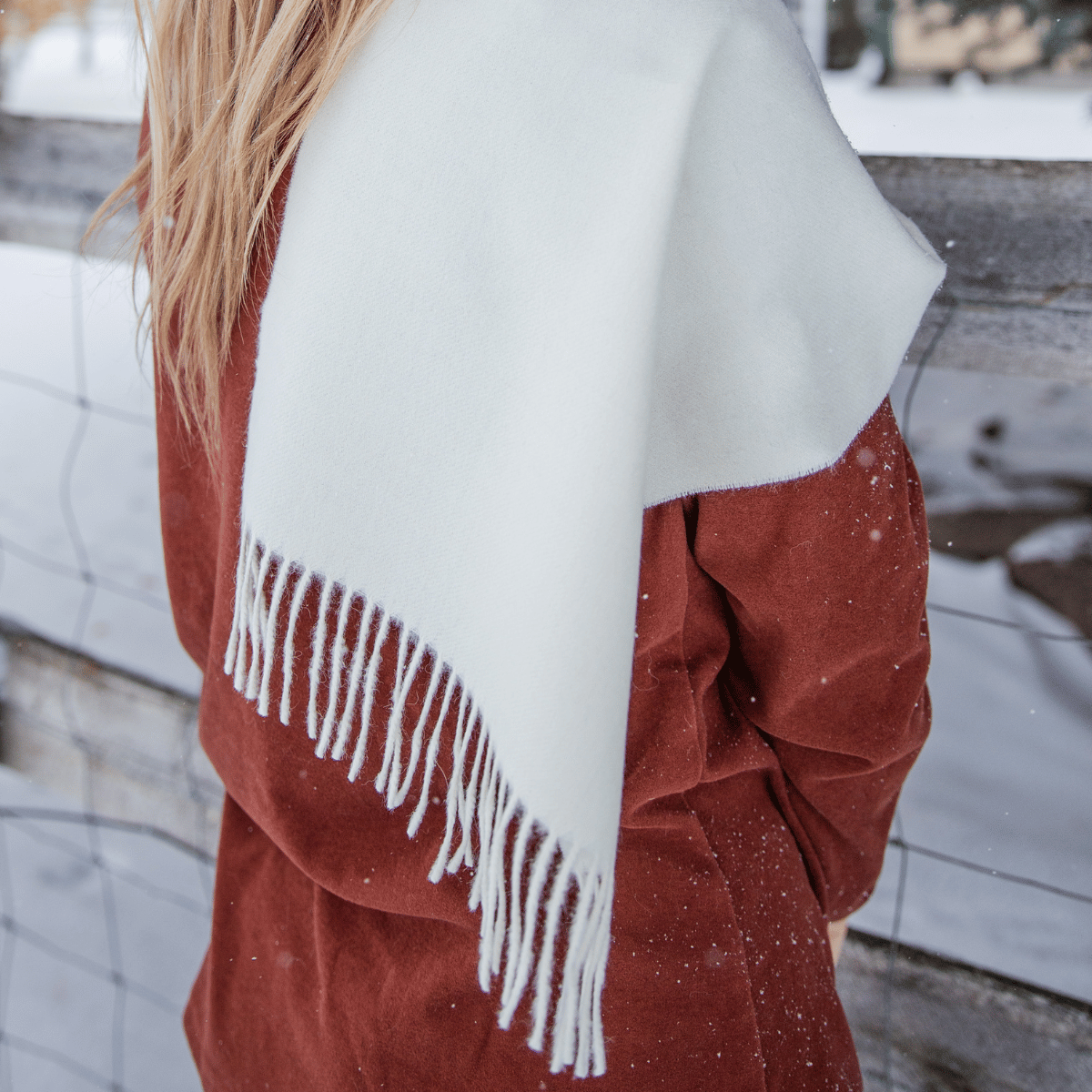 A close up of an Alpacas of Montana soft stylish women's fashion comfortable cozy cute warm alpaca wool natural white solid woven scarf with tassels.