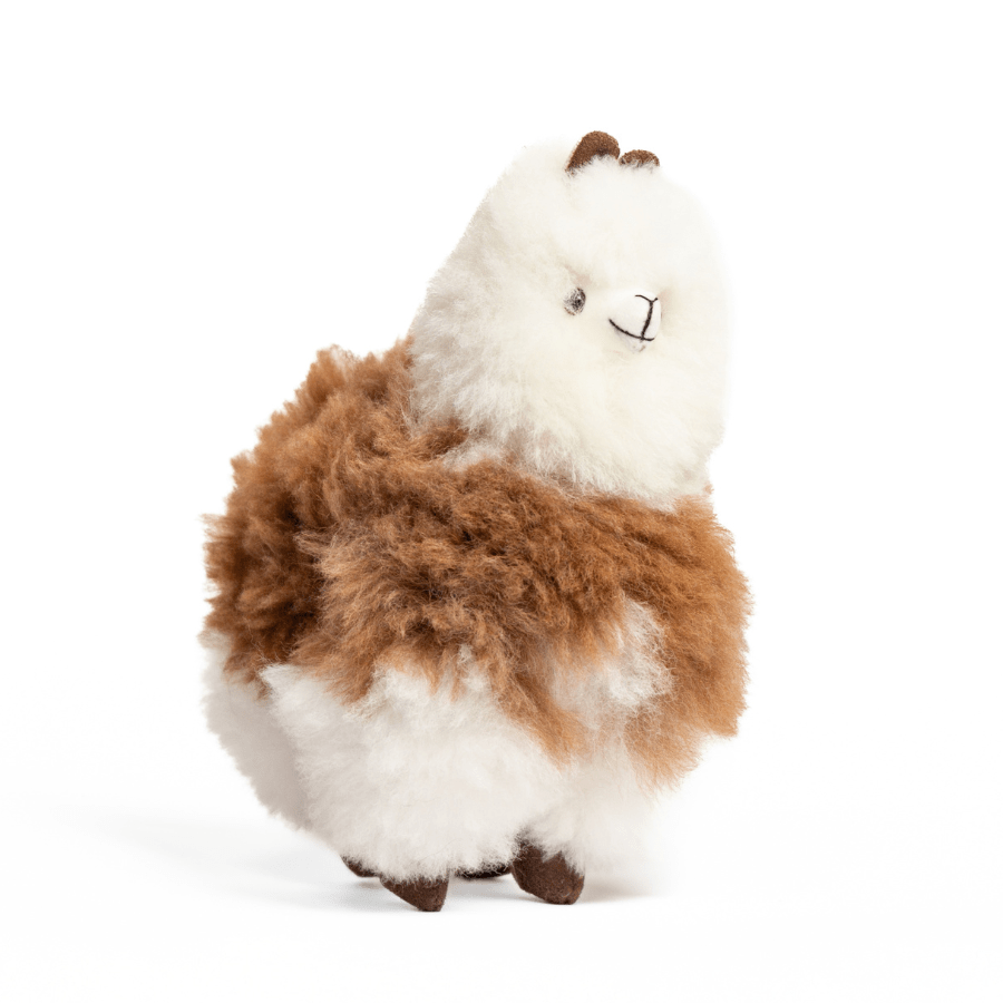 A brown and white plush toy resembling an alpaca with beige fleece, black eyes, and a brown nose.