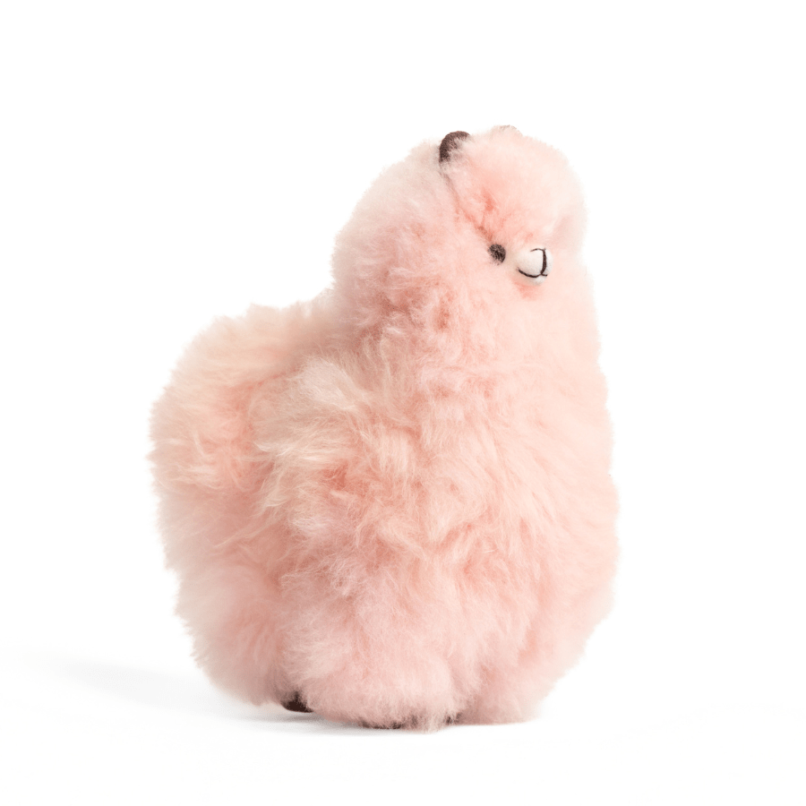 A pink alpaca plush toy resembling an alpaca with beige fleece, black eyes, and a brown nose.