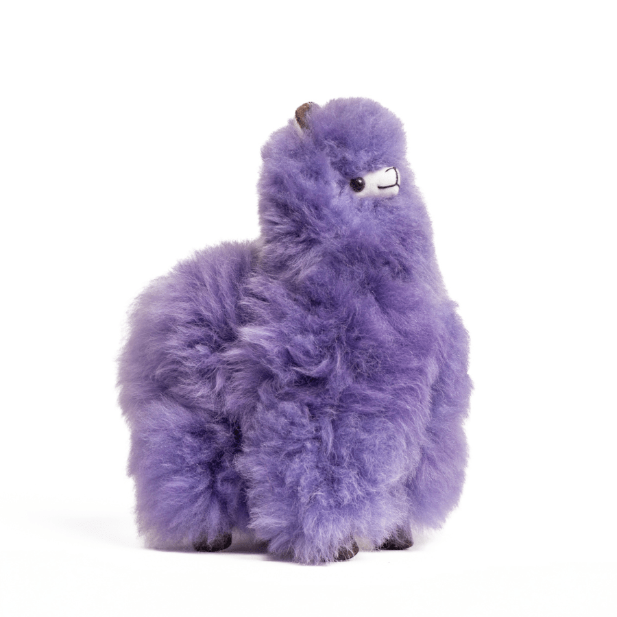 A plush purple toy resembling an alpaca with beige fleece, black eyes, and a brown nose.