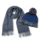 Gray scarf and blue knit hat with pom-pom on a white background