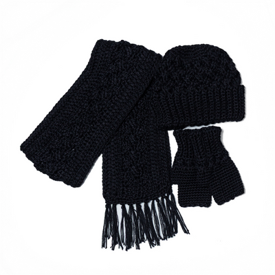 A woman wearing a black hat, wrist warmers, and a scarf, smiling at the camera.