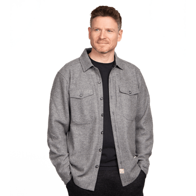 A man wearing a gray alpaca baby shirt jacket with a soft fleece lining, designed for both casual and outdoor activities.