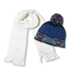 White scarf and blue knitted hat with colorful patterns on a white background