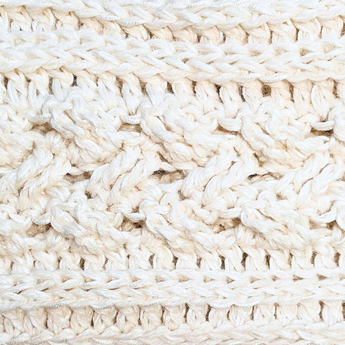 A close up photograph of the warm cozy handmade knit crochet Alpacas of Montana scarf in the color natural white.