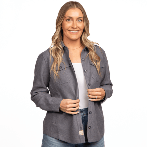 A woman wearing a gray alpaca shacket over a white top, paired with jeans.