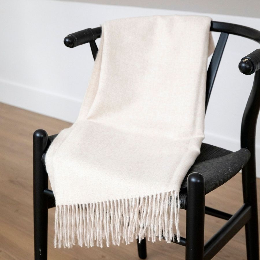 creamy beige alpaca wool blanket sitting on black chair