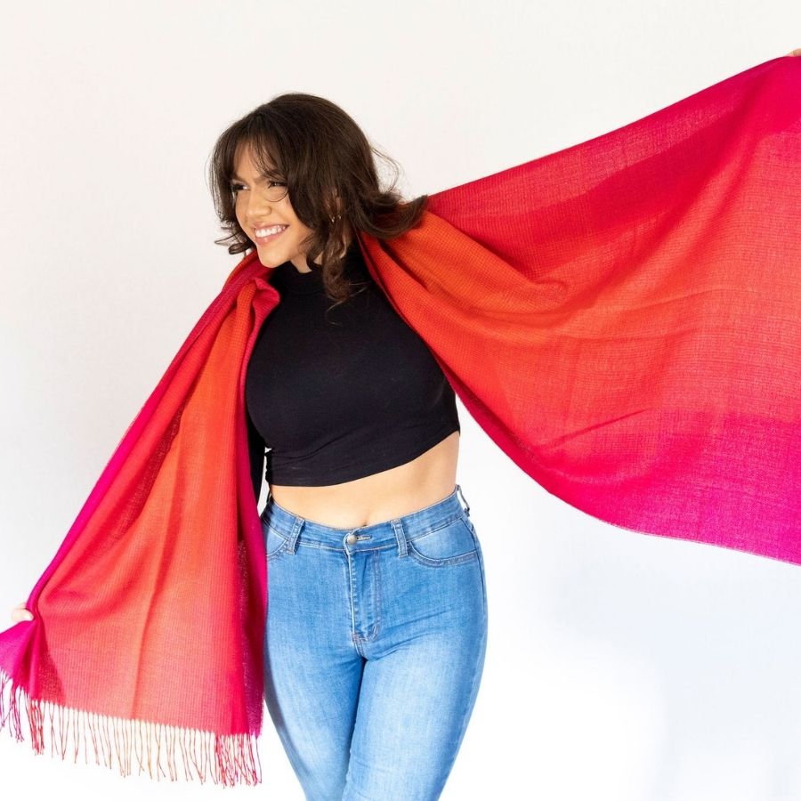woman smiling with warm pink alpaca wool shawl wrapped around her shoulders