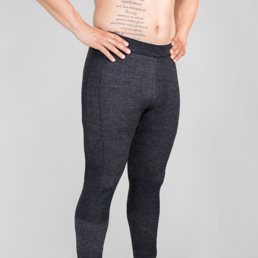 A photo from the waist down of a man standing with his hands on his hips in front of a white background. He is shirtless and wearing a pair of the Alpacas of Montana warm underlayer cozy comfortable thermal moisture wicking long johns winter outerwear heavyweight antimicrobial alpaca wool men's red and black base layer bottoms for skiing, snowboarding, ice fishing, hunting, camping, arctic, travel
