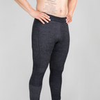 A photo from the waist down of a man standing with his hands on his hips in front of a white background. He is shirtless and wearing a pair of the Alpacas of Montana warm underlayer cozy comfortable thermal moisture wicking long johns winter outerwear heavyweight antimicrobial alpaca wool men's red and black base layer bottoms for skiing, snowboarding, ice fishing, hunting, camping, arctic, travel
