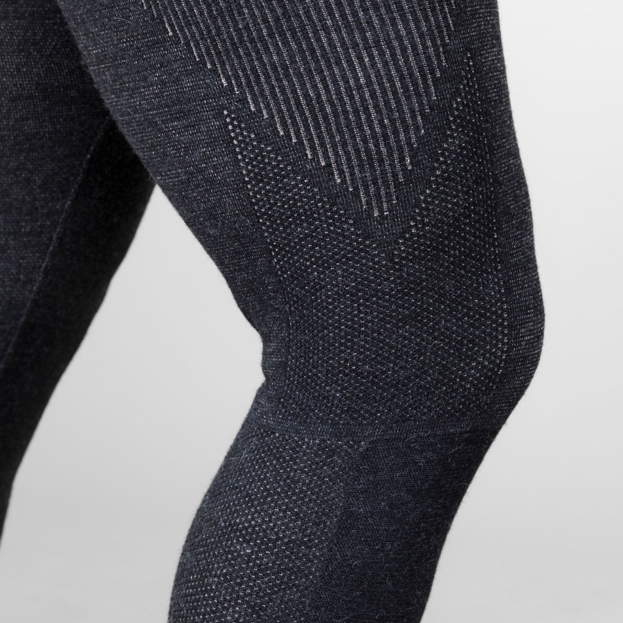 A close up photo of a person's leg and knee against a white background. The person is wearing a pair of the Alpacas of Montana warm underlayer cozy comfortable thermal moisture wicking long johns winter outerwear heavyweight antimicrobial alpaca wool men's red and black base layer bottoms for skiing, snowboarding, ice fishing, hunting, camping, arctic, travel