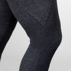 A close up photo of a person's leg and knee against a white background. The person is wearing a pair of the Alpacas of Montana warm underlayer cozy comfortable thermal moisture wicking long johns winter outerwear heavyweight antimicrobial alpaca wool men's red and black base layer bottoms for skiing, snowboarding, ice fishing, hunting, camping, arctic, travel
